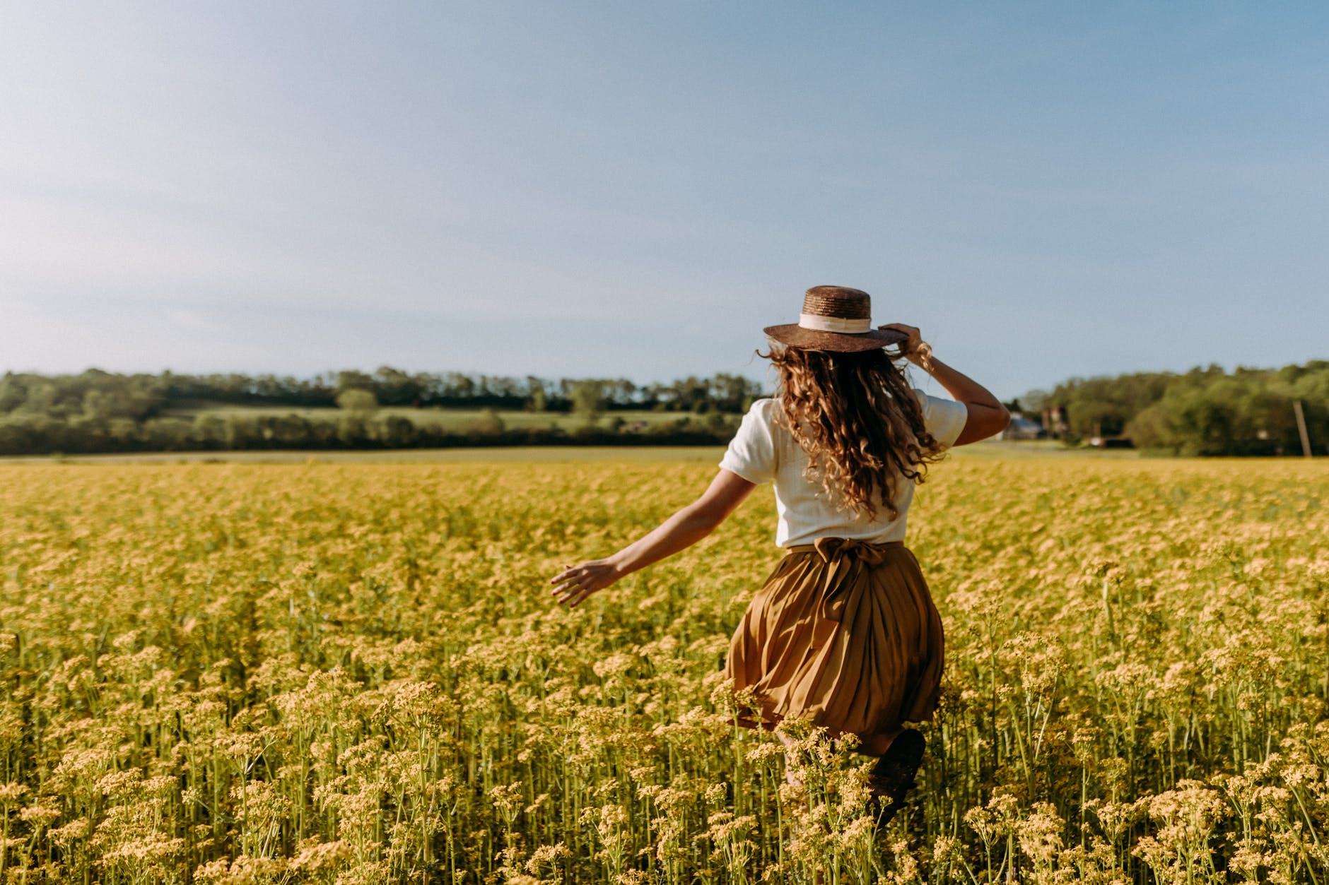 woman running through canola field