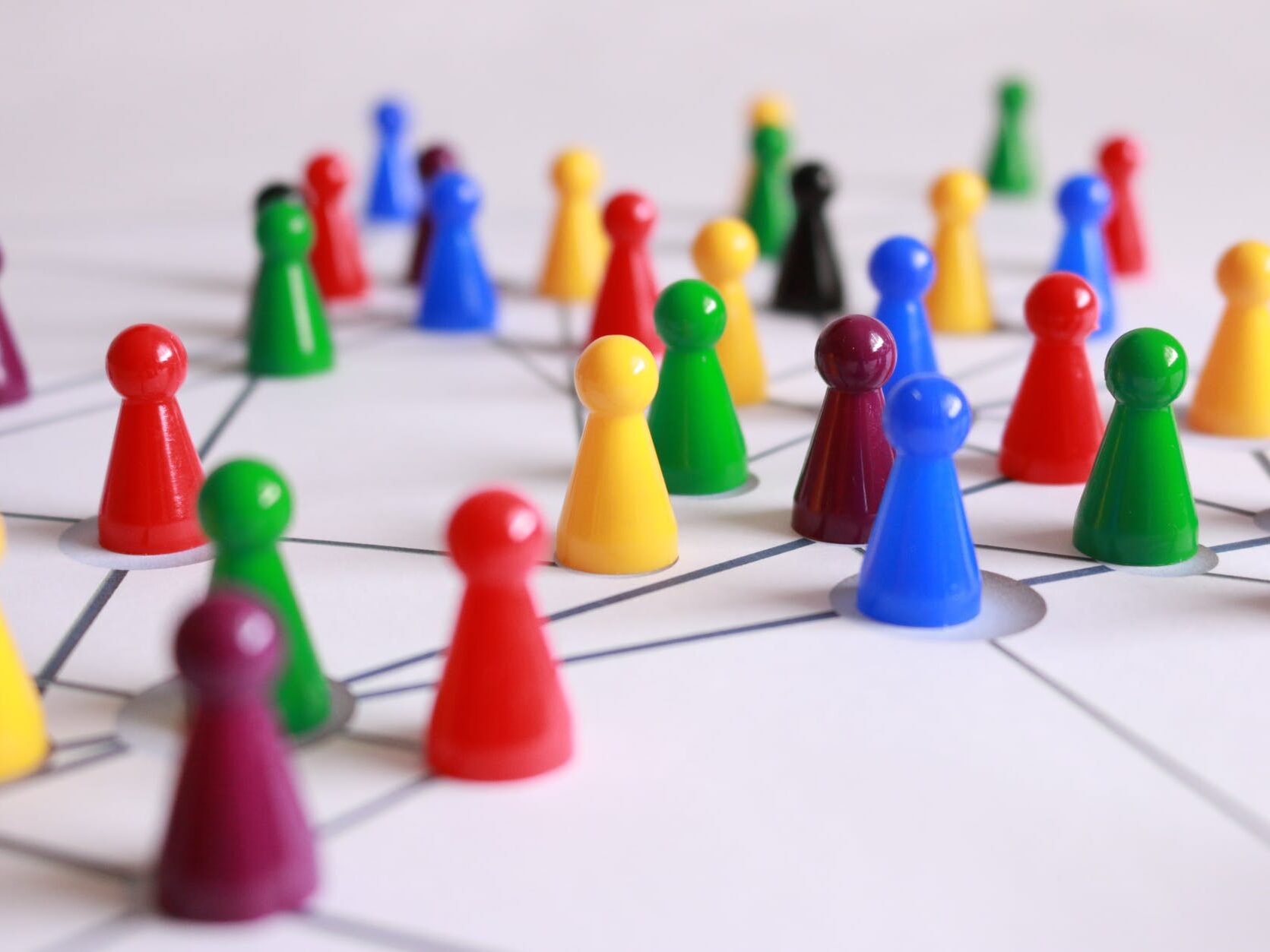 close up photography of yellow green red and brown plastic cones on white lined surface